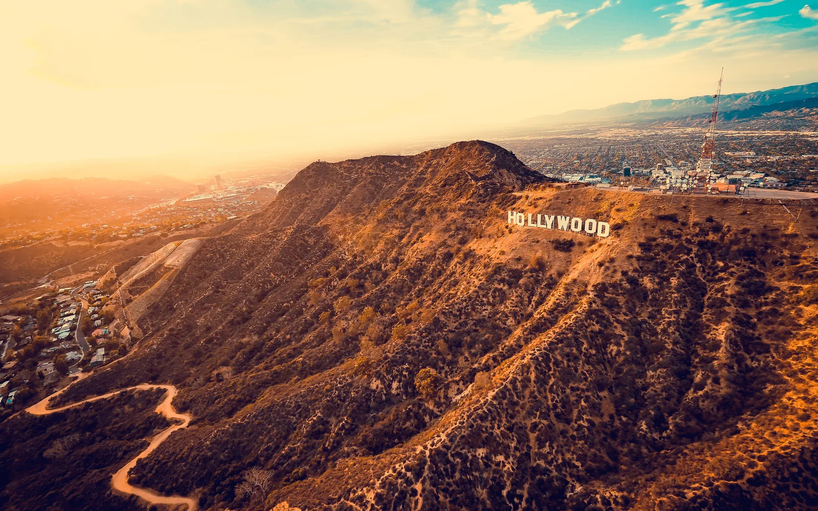 Aerial view of the Hollywood Sign on the slope of Mount Lee with Los Angeles spreading out behind it